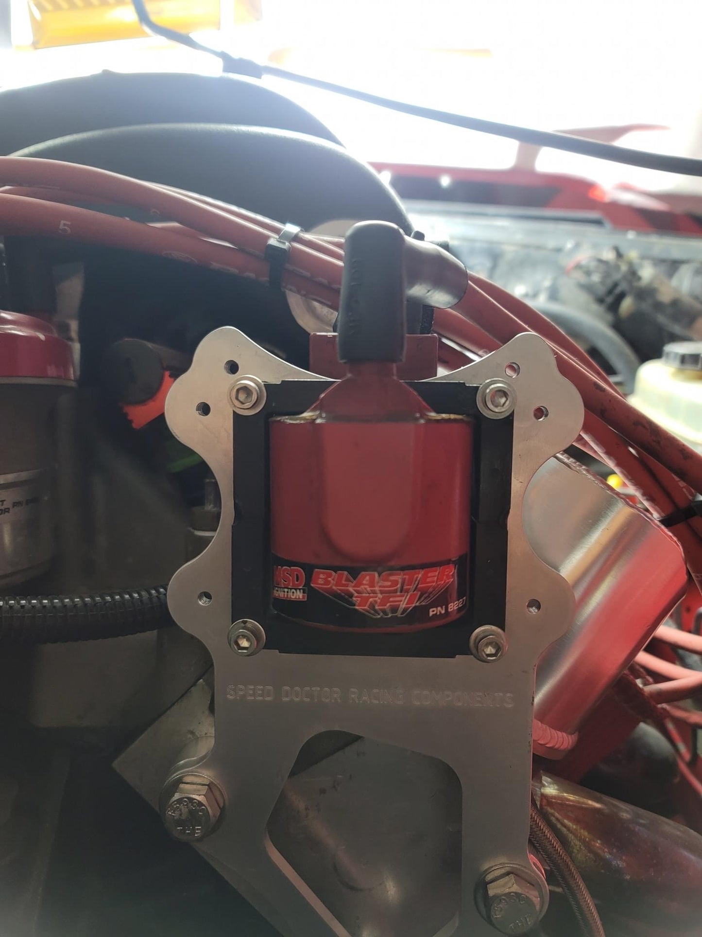 Universal ignition coil bracket mounted on engine